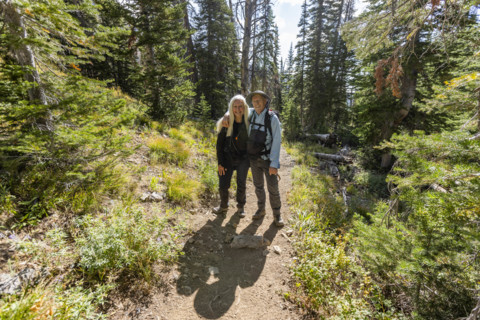 USA, Idaho, Sun Valley, Portrait of smiling senior couple standing on footpath in forest