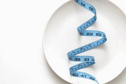 Blue tape measure on empty plate