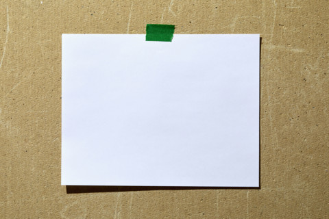 Blank paper taped to rough textured wall