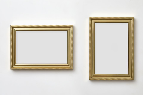 Gold decorative picture frames on white wall
