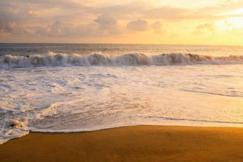 Mexico, Oaxaca State, Puerto Escondido, Costa Chica, Clouds over ocean waves on empty beach at