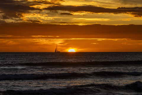 Costa Rica, Guanacaste, Playa Grande, Silhouette of sailboat on sea horizon at sunset