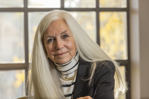 USA, Idaho, Boise, Portrait of smiling senior woman with long white hair in office