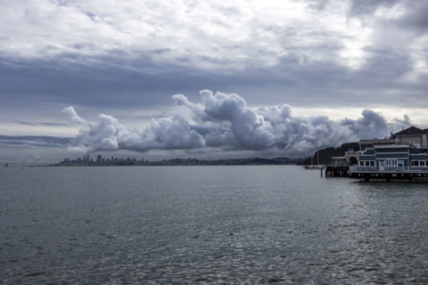 USA, California, Sausalito, Puffy clouds above city skyline across bay