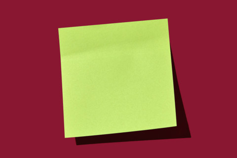 Blank green post it note on red background