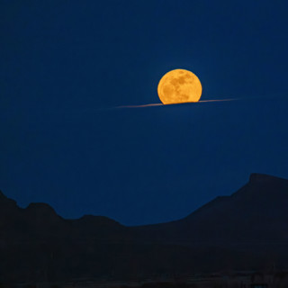Pink Moon rising over cloud bank. Bellevue, Idaho, USA.