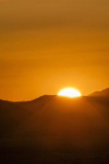 Sun setting above hills against orange sky. Bellevue, Idaho, USA.