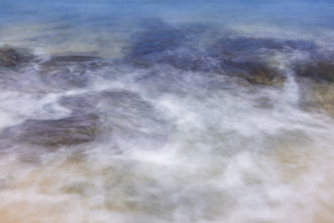 Close-up of motion blurred ocean water on sand. Kona, Hawaii, USA.