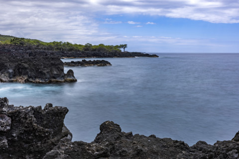 Motion blur ocean and rocky coastline. Kona, Hawaii, USA.