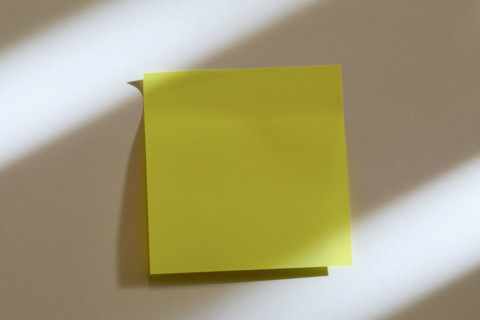 Blank yellow post it note on wall. New York City, New York State, USA.