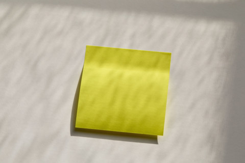 Blank yellow post it note on wall. New York City, New York State, USA.