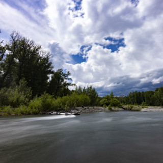 Clouds above motion blurred Big Wood River. Bellevue, Idaho, USA.