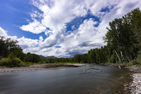 Clouds above motion blurred Big Wood River. Bellevue, Idaho, USA.