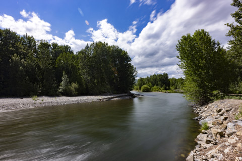 Clouds above motion blurred Big Wood River. Bellevue, Idaho, USA.
