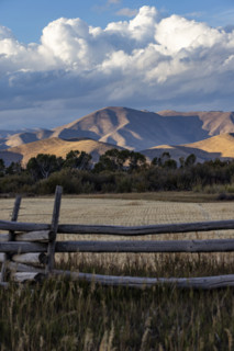 White puffy clouds over mountains and field. Bellevue, Idaho, USA.