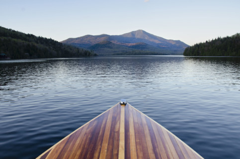 Bow of wooden boat on Lake Placid. Lake Placid, New York State, USA.