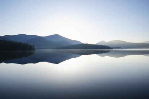 Whiteface Mountain reflected on surface of Lake Placid at sunrise. Lake Placid, New York State, USA