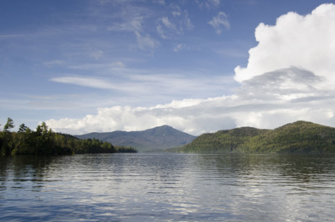 Puffy clouds over calm lake Placid . Lake Placid, New York State, USA.