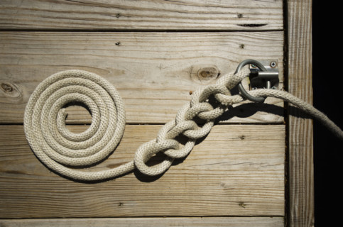 Boat rope tied and coiled on boat dock. Lake Placid, New York State, USA.