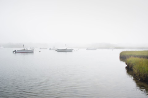 Early morning fog covering boats anchored at Madaket Harbor. Nantucket, Massachusetts, USA.