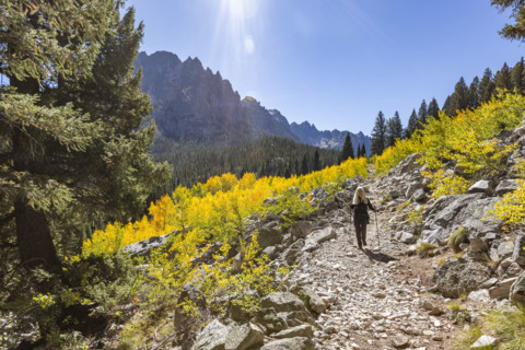 Senior woman hiking in Sawtooth Mountains on sunny day. Stanley, Idaho, USA.