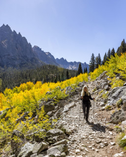 Senior woman hiking in Sawtooth Mountains on sunny day. Stanley, Idaho, USA.