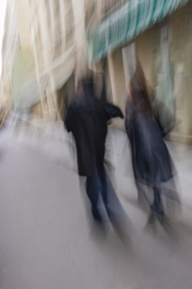 Rear view of couple walking down street, blurred motion. Paris, Ile de France, France.