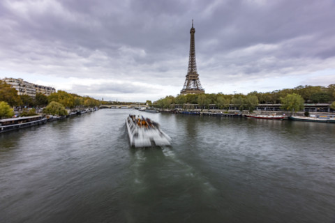 Sightseeing boat along Seine river with Eiffel Tower in background. Paris, Ile de France, France.