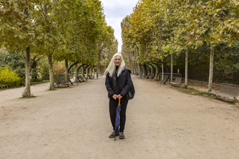 Portrait of smiling woman in Jardin des Plantes. Paris, Ile de France, France.