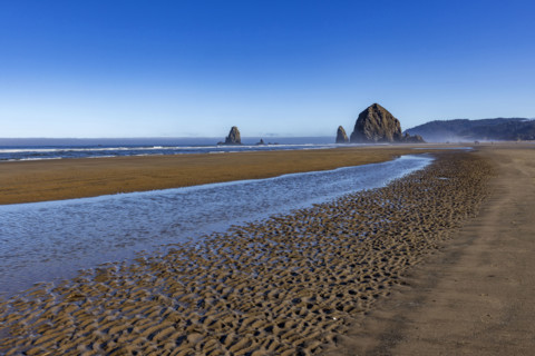 Cannon Beach at low tide with Haystack Rock in background. , Oregon, USA.