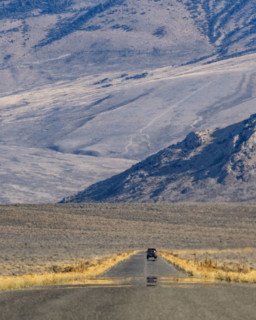 Lone vehicle on rural road over Trail Creek Pass. Mackay, Idaho, USA.