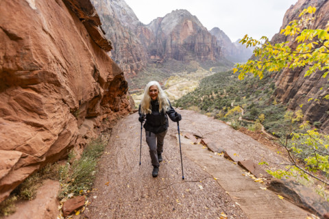 Senior blonde woman hiking trail to Angels Landing. , Utah, USA.