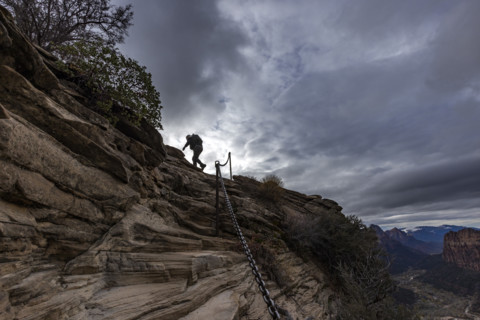 Low angle view of female hiker climbing top of Angels Landing. , Utah, USA.