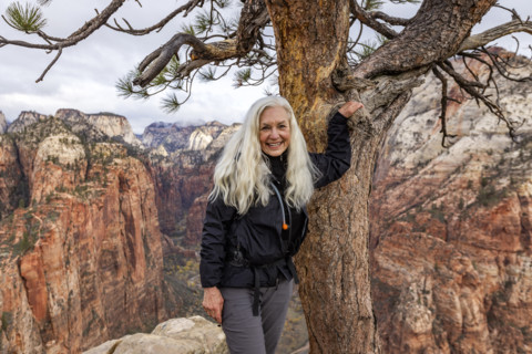 Portrait of senior blonde woman on Angels Landing. , Utah, USA.