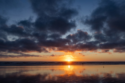 Sun setting over calm ocean. Oceanside, California, USA.