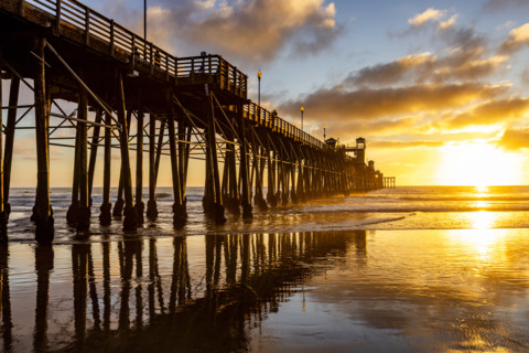 Oceanside Pier and calm ocean at sunset. Oceanside, California, USA.