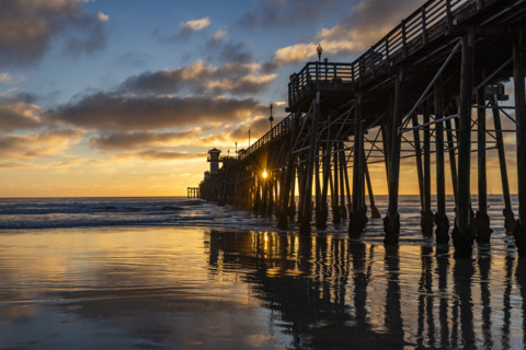 Oceanside Pier and calm ocean at sunset. Oceanside, California, USA.