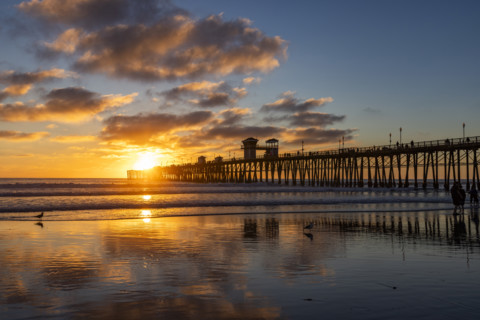 Oceanside Pier and calm ocean at sunset. Oceanside, California, USA.