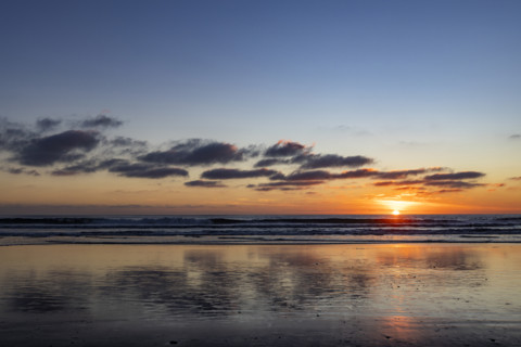 Sun setting over calm ocean. Oceanside, California, USA.