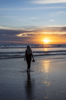 Rear view of woman walking on beach at sunset. , Guanacaste, Costa Rica.