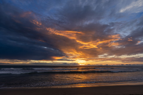 Sun setting above calm sea and Playa Grande. , Guanacaste, Costa Rica.