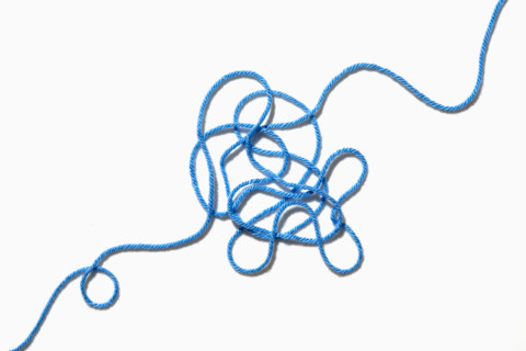 Tangled blue yarn on white background. New York City, New York State, USA.