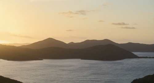 Calm ocean and mountains at sunrise. New York City, New York State, USA.