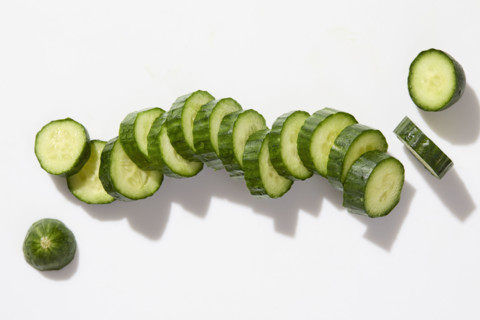 Sliced cucumber on white background. New York City, New York State, USA.