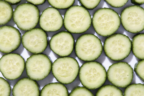 Sliced cucumber on white background. New York City, New York State, USA.
