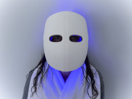 Studio shot of woman using LED light therapy mask, Nashville, Tennessee, USA.