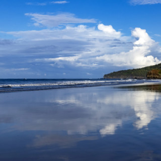 Sky and clouds reflecting in calm sea surface at dawn, Playa Grande, Guanacaste, Costa Rica.