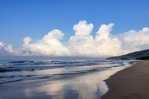 Sky and clouds reflecting in calm sea surface at dawn, Playa Grande, Guanacaste, Costa Rica.