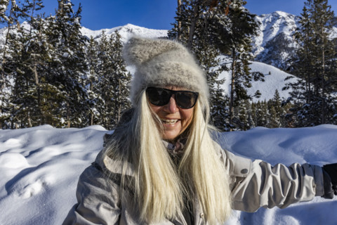 Portrait of smiling senior woman in snowy landscape, Sun Valley, Idaho, USA.