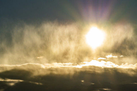 Sun glowing above cloud bank, Bellevue, Idaho, USA.